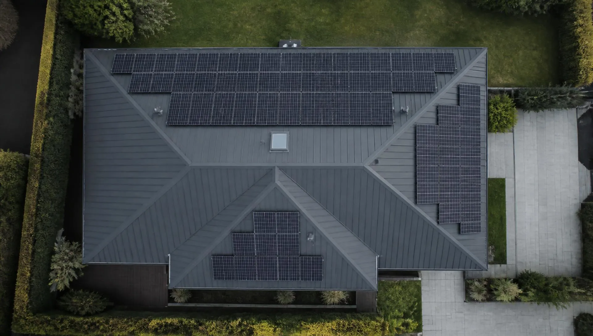 Vue aérienne d'une maison contemporaine dont les panneaux sont répartis sur plusieurs pans de toiture, donc plusieurs orientations